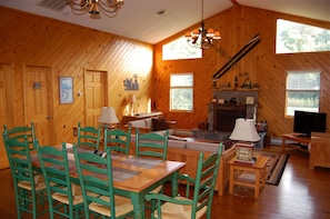 Large living room has a gas stone fireplace and family dining area.