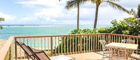 Enjoy the expansive deck overlooking the ocean framed by two tall coconut trees