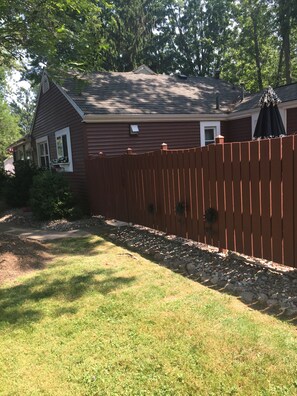 Fence encloses  outdoor area adding privacy to enjoy meals and camaraderie 