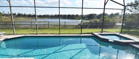 Beautiful south-facing pool deck with lake views, loungers, dining area