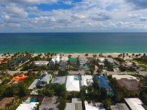 Home in center with gleaming white roof is just 100 yards from the beach.