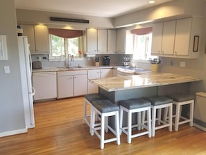 Freshly-painted kitchen with new Quartzite countertop is fully stocked.
