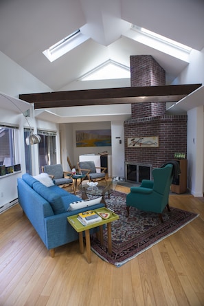 Soaring ceilings and skylights in the sun-filled living room.
