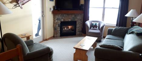 Cozy Fireplace with Door out to the Large Balcony