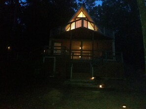 LAKE SIDE OF HOUSE AT NIGHT FEATURES LIGHTED PATH TO DOCK