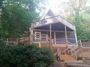 LAKE SIDE OF HOUSE WITH GRILL DECK ABOVE AND SCREENED PORCH AND HOT TUB BELOW