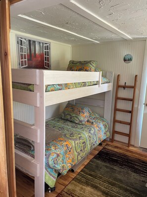 Loft bed separated from living area by barn door. 