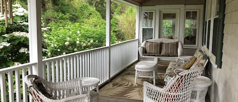 Side porch with wicker furniture for those relaxing moments.