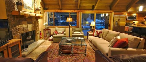 The Great Room that has the feel of the outdoors with large windows skylights in the vaulted timber ceiling and wood burning fireplace 