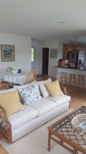 Living room looking into kitchen. Inside dining table plus stools / granite top.