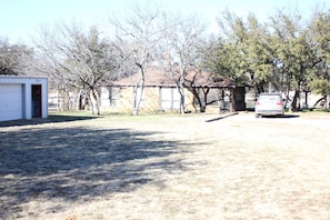 View from front driveway.  Entry gate behind where pic taken from.  FUN treehouse with several swings and platform is in the tree area to the left of where pic is taken.