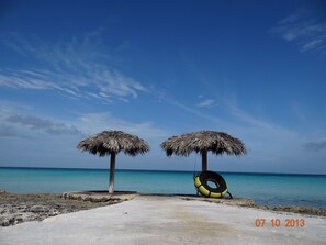 Walkway to the water, palapas offer shade.