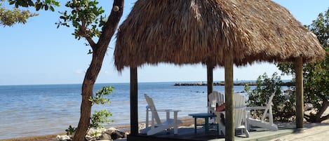 Relax by the Atlantic Ocean under a thatched hut.