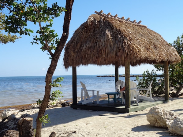 Relax by the Atlantic Ocean under a thatched hut.
