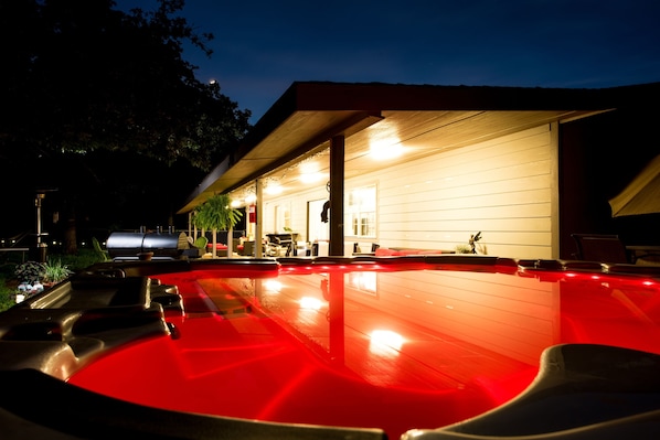 Night time Hot tub facing back porch 