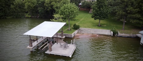Aerial view of the boat dock, steps leading into the lake  and swimming area. 