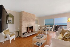 Oceanfront living area with wood burning fireplace and flat screen HD TV