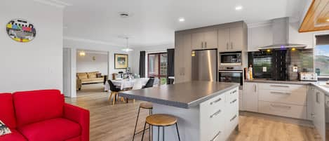 Open plan kitchen, family, dining, peeking into the lounge.