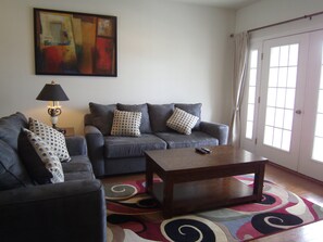  Designer sofa, French door leading to the  balcony with table and chairs.
