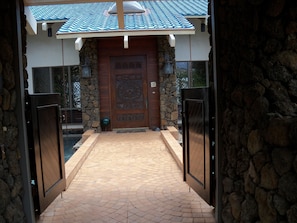 Entry bridge over pond leading to grand hand carved front door 