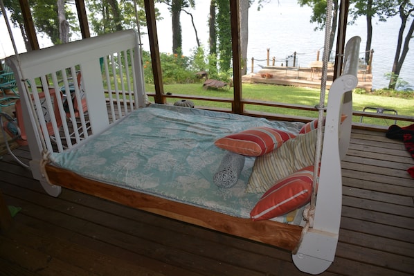 Queen-size hanging bed on spacious  porch is wonderful for napping and reading.