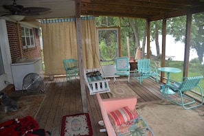 Lakeside screened porch is  favorite  gathering 424 spot with swing bed.