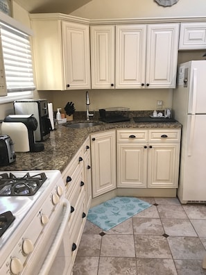 Granite countertops with soft-close cabinets and tile flooring