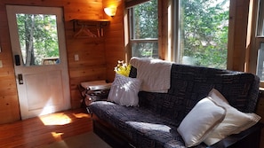 Living room with futon with a comfortable full-size mattress.