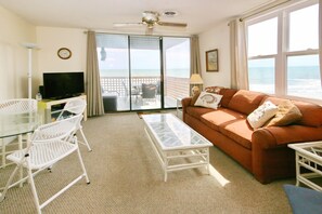 Living room with memory foam sleeper sofa, cable TV, breakfast nook, and balcony