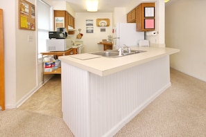 Fully stocked kitchen with dishes, cookware, microwave, coffee maker, oven, etc