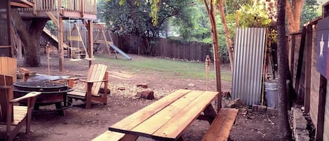 Backyard with fire pit, 8ft table, tree house & swings - lots of room to relax!