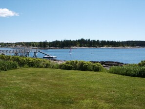 View of front lawn and dock.  Windsurfer enjoying Harbor. 