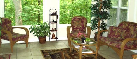 Sunroom with beautiful view of forest during Summer.