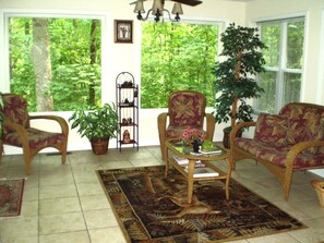 Sunroom with beautiful view of forest during Summer.
