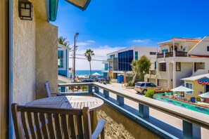 View of ocean from small private balcony with 2 chairs and table