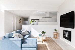 Downstairs lounge room with bi-fold doors that open onto alfresco deck