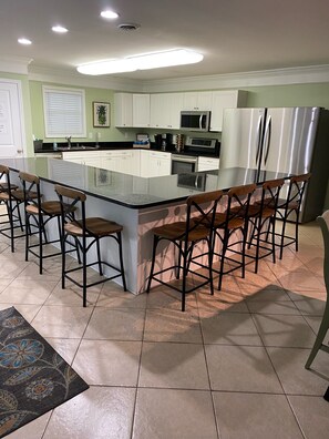 Open kitchen with large bar and seating for 8. 