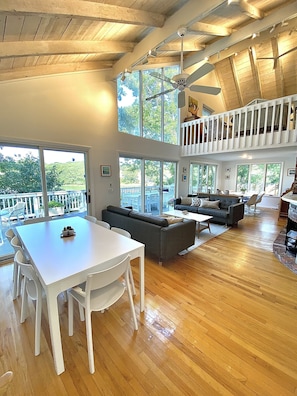 The great room includes 2 dining tables and abuts the kitchen and upper deck.