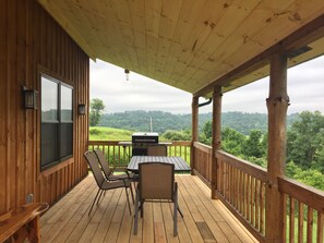 Large porch with grill, table, chairs, bench