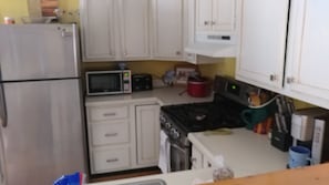 Stainless gas stove joins stainless fridge & microwave in the kitchen. 