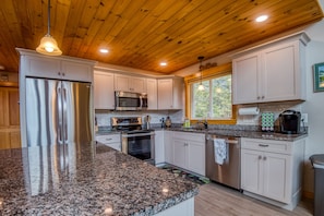 Kitchen w/ fully stocked pantry, granite counters and stainless steel appliances