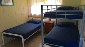 A single bed + a set of double bunks, fan & security on windows