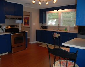 Large, sunny kitchen with new flat top stove and breakfast bar