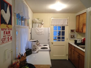 Galley kitchen w/ door leading to outdoor shower, patio & basement laundry room