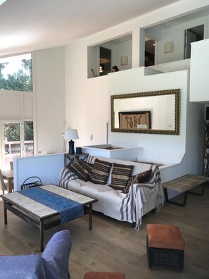 The living room with views over pool and Andrakas w/ a chimney.