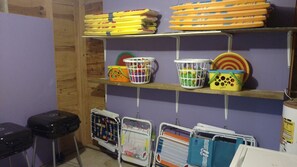 The utility room houses beach toys, boogie boards, beach chairs, and grill