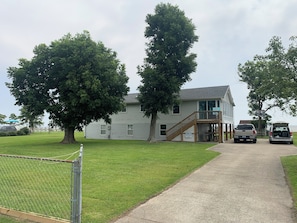 House is located in the center of a lg fenced yard, nestled behind 2 Pecan trees