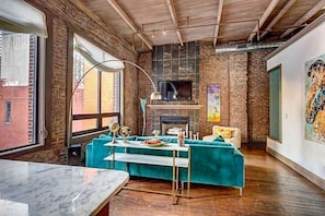 Fireplace in living area with large windows overlooking Printers Alley