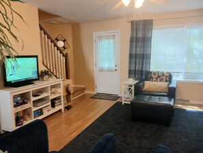 Living room with large 
tv and  stairs to the bedroom level 