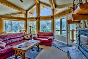 Ample seating area in front of river rock floor to ceiling gas fireplace.